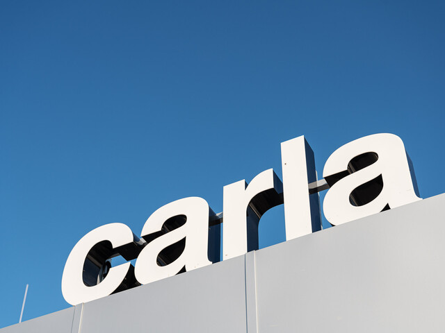 Das carla Logo vor strahlend blauem Himmel.