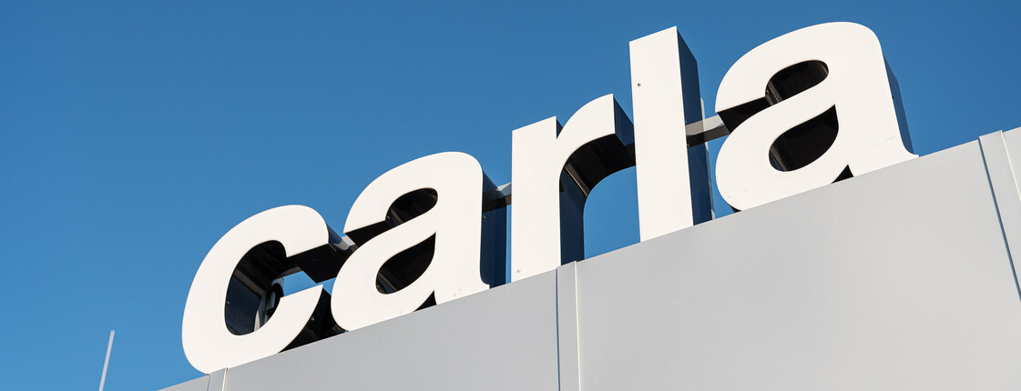 Das carla Logo vor strahlend blauem Himmel.