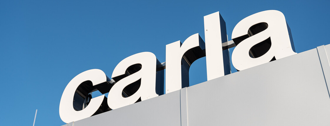 Das carla Logo vor strahlend blauem Himmel.